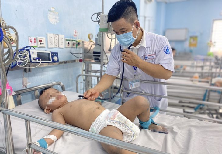 Bác sĩ CKII Dư Tuấn Quy, trưởng khoa nhiễm - thần kinh Bệnh viện Nhi đồng 1 (TP.HCM), thăm khám một bệnh nhi mắc tay chân miệng ngày 9-10 - Ảnh: XUÂN MAI